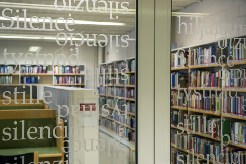 Näkymä kirjaston lukusaliin ovi-ikkunan läpi | A view to a library reading room through a window in a door