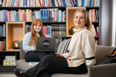 Avoimessa yliopistossa opiskelleet Kielo Kitunen ja Aino Mäkinen yhteiskuvassa kirjastotilassa.