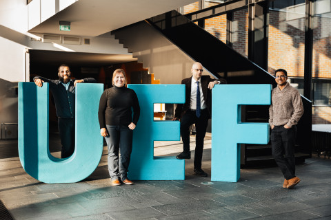 Four young researchers standing with the big letters U, E, F.